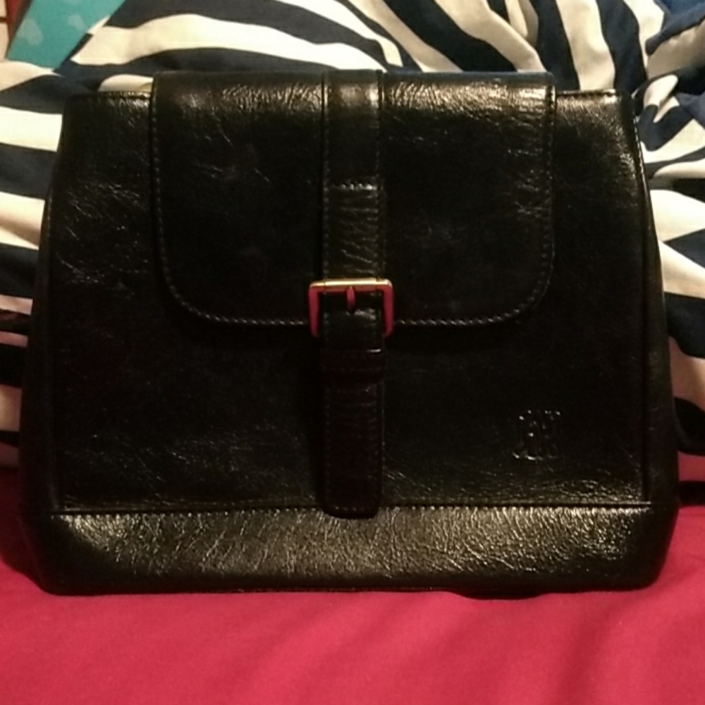 Black purse with brass accents and crossbody strap